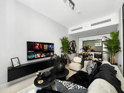 a living room with a couch and a tv at Modern 2 Bed in Dubai Hills Near Mall & Park in Dubai
