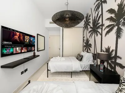 a bedroom with two beds and a flat screen tv at Modern 2 Bed in Dubai Hills Near Mall & Park in Dubai