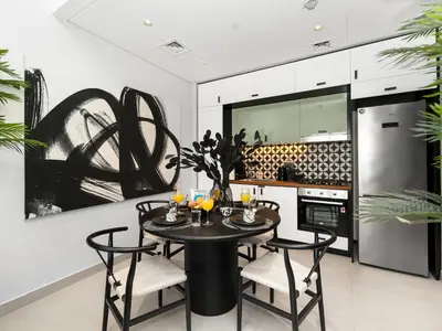 a kitchen with a black table and chairs and a refrigerator at Modern 2 Bed in Dubai Hills Near Mall & Park in Dubai