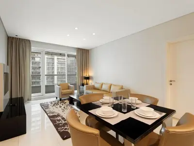 a dining room and living room with a table and chairs at Water Edge Damac Maison Canal View 1BR Perfect Grand Getaway in Dubai
