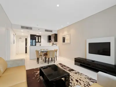 a living room with a couch and a table at Water Edge Damac Maison Canal View 1BR Perfect Grand Getaway in Dubai