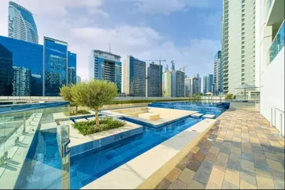 a pool in the middle of a city with tall buildings at Elegant 1BR Apartment at DAMAC Vera in Business Bay in Dubai
