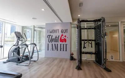 a gym with two tread machines and a sign at Elegant 1BR Apartment at DAMAC Vera in Business Bay in Dubai