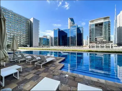 a swimming pool with a city skyline in the background at Elegant 1BR Apartment at DAMAC Vera in Business Bay in Dubai