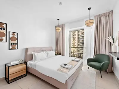 a bedroom with a bed and a green chair at Luxury 2-BDR in Downtown 8 BLVD Walk in Dubai