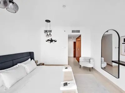 a bedroom with a bed and a mirror and a chair at Luxury 2-BDR in Downtown 8 BLVD Walk in Dubai