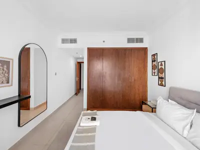 a bedroom with a white bed and a wooden door at Luxury 2-BDR in Downtown 8 BLVD Walk in Dubai