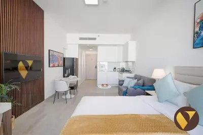 a living room with a white couch and a living room with at Vogue JVC Luma22 near Circle Mall, Studio Apartment with Balcony and Vibrant Community View, Access to all Amenities in Dubai