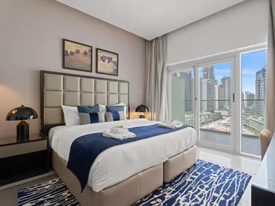 a bedroom with a large bed and a large window at Sunlit Studio Haven Luxury Living in Majestine in Dubai