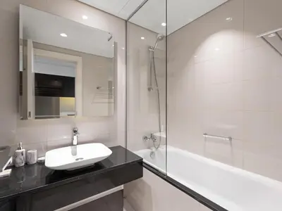 a white bathroom with a sink and a tub at Sunlit Studio Haven Luxury Living in Majestine in Dubai