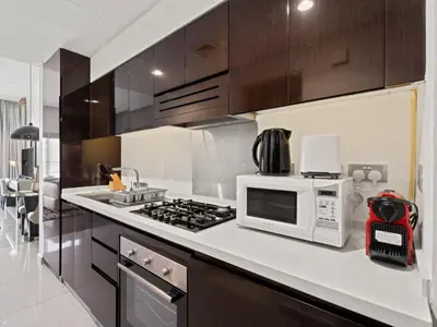 a kitchen with a microwave and a stove top oven at Sunlit Studio Haven Luxury Living in Majestine in Dubai