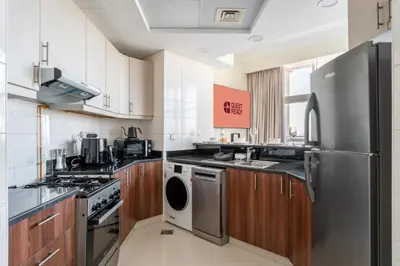 a kitchen with stainless steel appliances and wooden cabinets at GuestReady - 1 BHK | Breathtaking Skyline Views in Dubai
