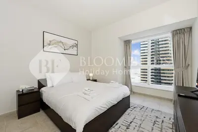 a bedroom with a bed and a large window at Bloomfields Iconic 2BR Elite Residence Marina in Dubai