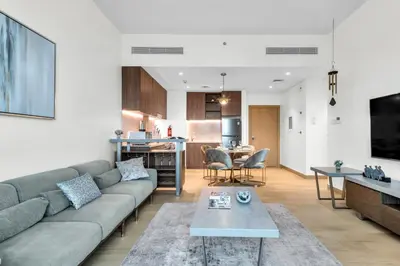 a living room with a couch and a table at Port De La Mer by Hosteeva in Dubai