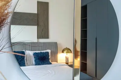 a bedroom with a bed and a mirror at Port De La Mer by Hosteeva in Dubai