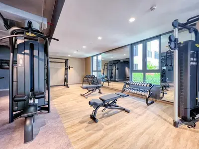 a gym with treadmills and benches in a room at Port De La Mer by Hosteeva in Dubai