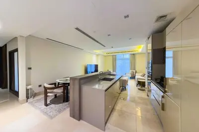 a kitchen and living room with a sink and a table at Palm Jumeirah, Fancy 2 Bedroom suite! in Dubai