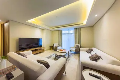a living room with white couches and a flat screen tv at Palm Jumeirah, Fancy 2 Bedroom suite! in Dubai