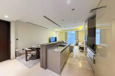 a kitchen and living room with a sink and a table at Palm Jumeirah, Fancy 2 Bedroom suite! in Dubai