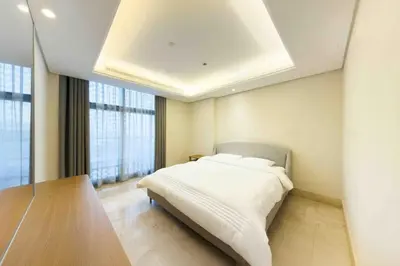 a bedroom with a white bed and a large window at Palm Jumeirah, Fancy 2 Bedroom suite! in Dubai