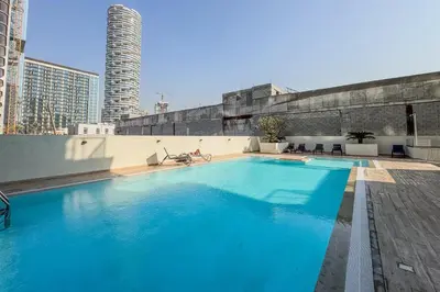 a large blue swimming pool on top of a building at Upscale Studio in Park View JVC in Dubai