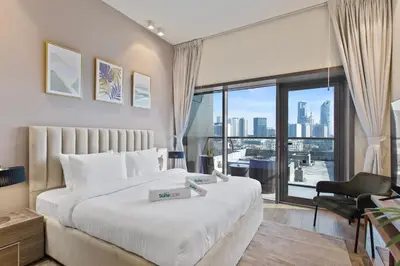 a bedroom with a large bed and a large window at Upscale Studio in Park View JVC in Dubai