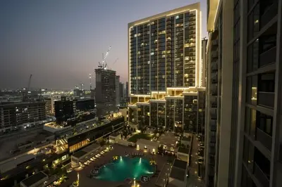 a view of a city at night with buildings at Luxury 1BR Apartment Near Burj Khalifa Skyline Pool View in Dubai