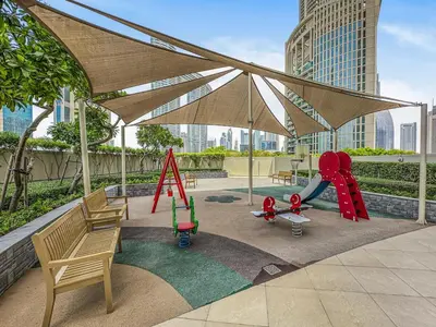 a playground with a slide and a swing at Ultra Modern Downtown Residence Steps Away from Burj Khalifa and Dubai Mall in Dubai