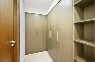 a walk in closet with wooden cabinets and a door at Ultra Modern Downtown Residence Steps Away from Burj Khalifa and Dubai Mall in Dubai