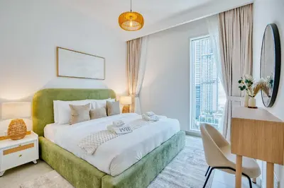 a bedroom with a large bed with a green headboard at PVH - Serene Central 2BR - Creek Horizon in Dubai