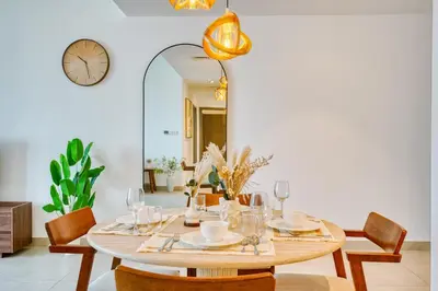 a dining room with a table and a mirror at PVH - Serene Central 2BR - Creek Horizon in Dubai