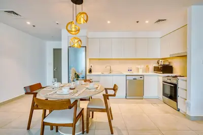 a kitchen with a table and chairs in a room at PVH - Serene Central 2BR - Creek Horizon in Dubai