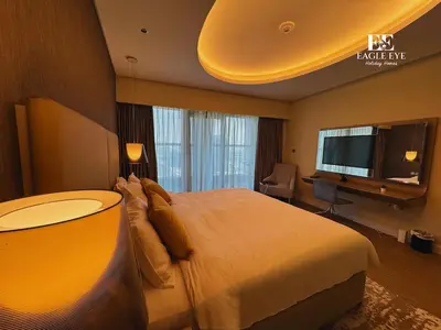 a hotel room with a large bed and a television at EEHH 1BR - 8 day NYE festival - Paramount - for 4 in Dubai