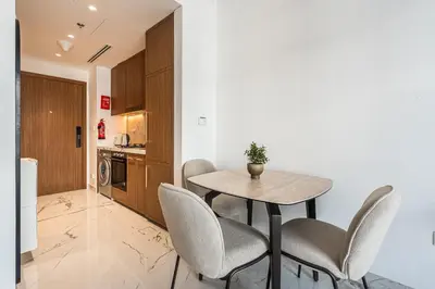 a kitchen and dining room with a table and chairs at Modern Studio Apartment with Outdoor views I Azizi 67 in Dubai