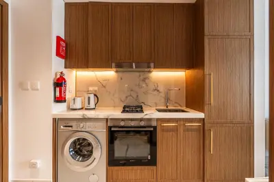 a kitchen with a stove and a washing machine at Modern Studio Apartment with Outdoor views I Azizi 67 in Dubai