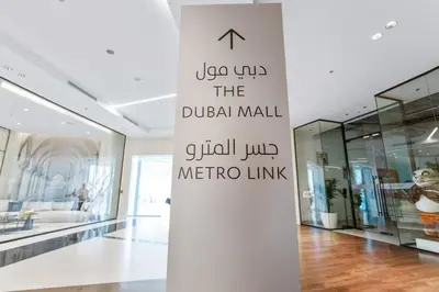 a white wall in a store with a sign at Connection to Dubai Mall, 2 King Beds, with Pool, Gym, Tennis Court in Dubai