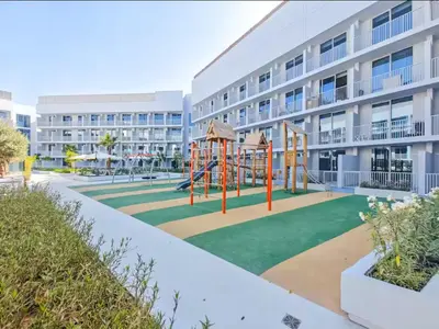 a playground in front of a apartment building at Vogue JVC Luma22 near Circle Mall, Studio Apartment with Balcony and Vibrant Community View, Access to all amenities in Dubai