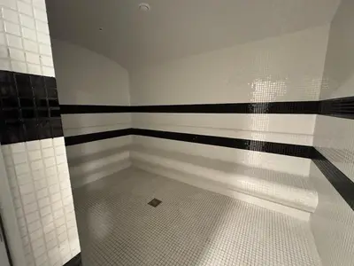 a bathroom with a shower with black and white tiles at Smart Studio in Gemz in Dubai