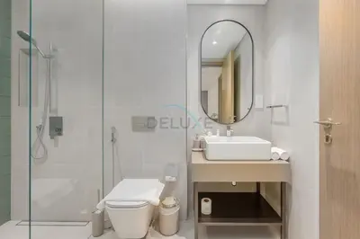 a bathroom with a toilet and a sink and a mirror at Prime location near the park, just minutes from the metro, with easy access to all of Downtown Dubai attractions, Viridian, Al Wasl by Deluxe Holiday Homes in Dubai