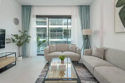 a living room with a couch and a table at Prime location near the park, just minutes from the metro, with easy access to all of Downtown Dubai attractions, Viridian, Al Wasl by Deluxe Holiday Homes in Dubai