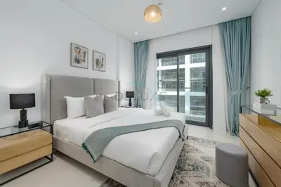 a bedroom with a bed and a large window at Prime location near the park, just minutes from the metro, with easy access to all of Downtown Dubai attractions, Viridian, Al Wasl by Deluxe Holiday Homes in Dubai
