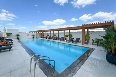 a large swimming pool on the roof of a hotel at Vogue JVC Luma22 near Circle Mall, Studio Apartment with Balcony and Vibrant Community View, Access to all Amenities in Dubai