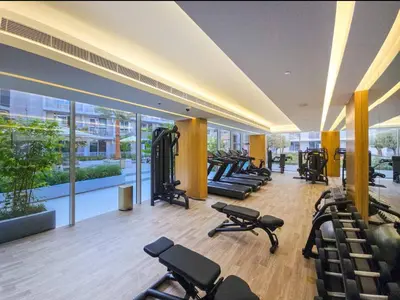 a gym with rows of exercise equipment in a building at Vogue JVC Luma22 near Circle Mall, Studio Apartment with Balcony and Vibrant Community View, Access to all Amenities in Dubai