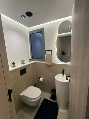 a bathroom with a toilet and a sink and a mirror at Brand New Luxury Home in a prime location in Dubai