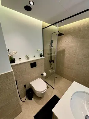 a bathroom with a toilet and a glass shower at Brand New Luxury Home in a prime location in Dubai