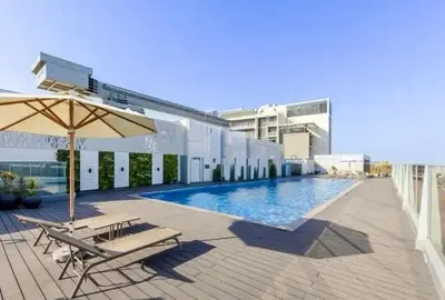 a pool with two chairs and an umbrella on a building at Brand New Luxury Home in a prime location in Dubai