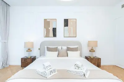 a bedroom with a white bed with two towels on it at PVH - Coastal 2BR with Beach Access - Atlantic Oceana in Dubai