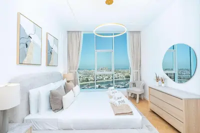 a white room with a bed and a large window at PVH - Coastal 2BR with Beach Access - Atlantic Oceana in Dubai