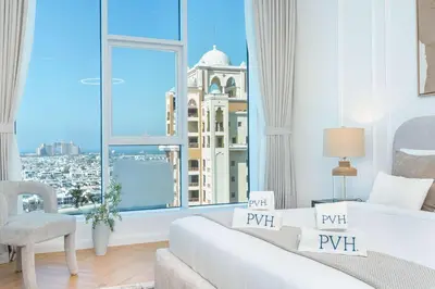 a bedroom with a large window with a view of a city at PVH - Coastal 2BR with Beach Access - Atlantic Oceana in Dubai