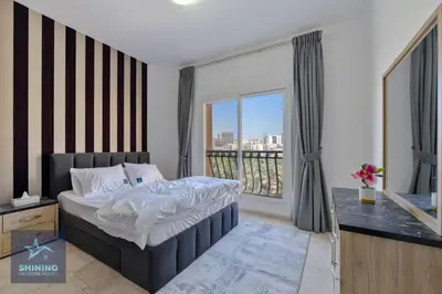 a bedroom with a bed and a large window at Peaceful 1BR JVC Near Circle Mall Pool Gym in Dubai